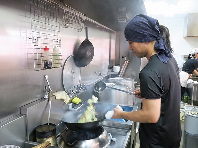 野菜を炒める店主